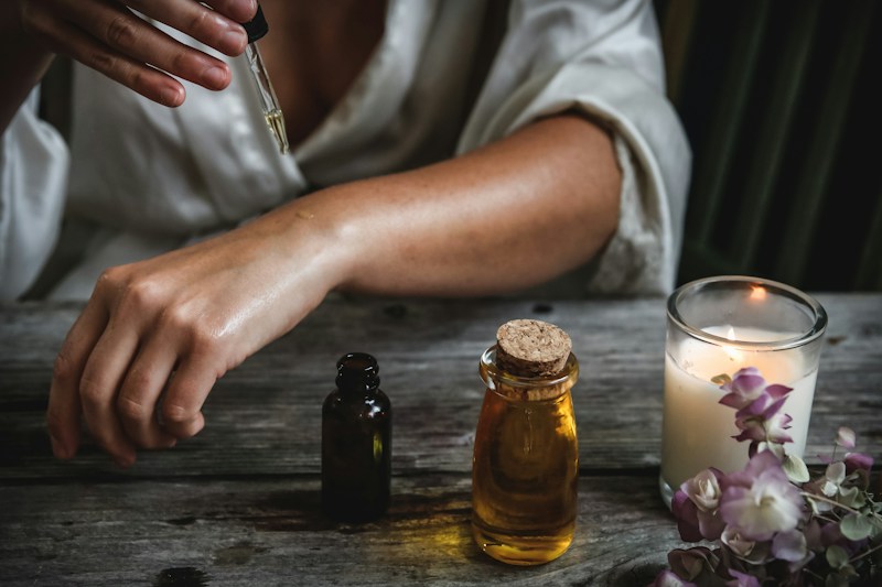 Essential oils and a candle on a wooden table