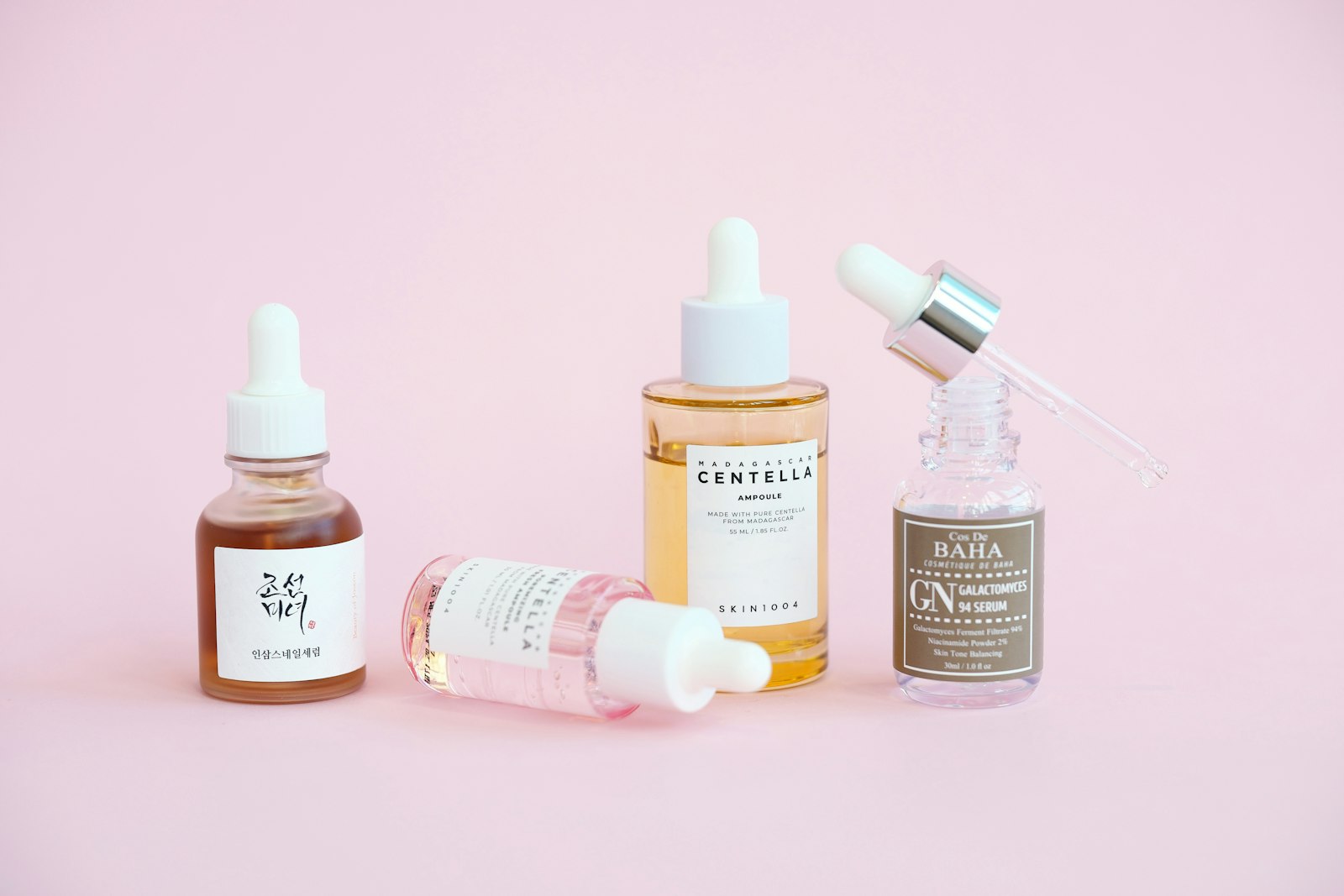 Serum and dropper bottles on a pink background